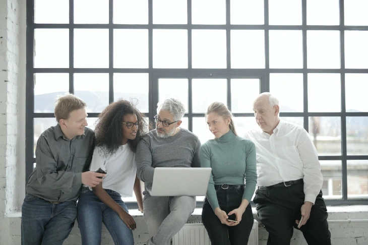 group-pope-discussing-while-looking-at-laptop